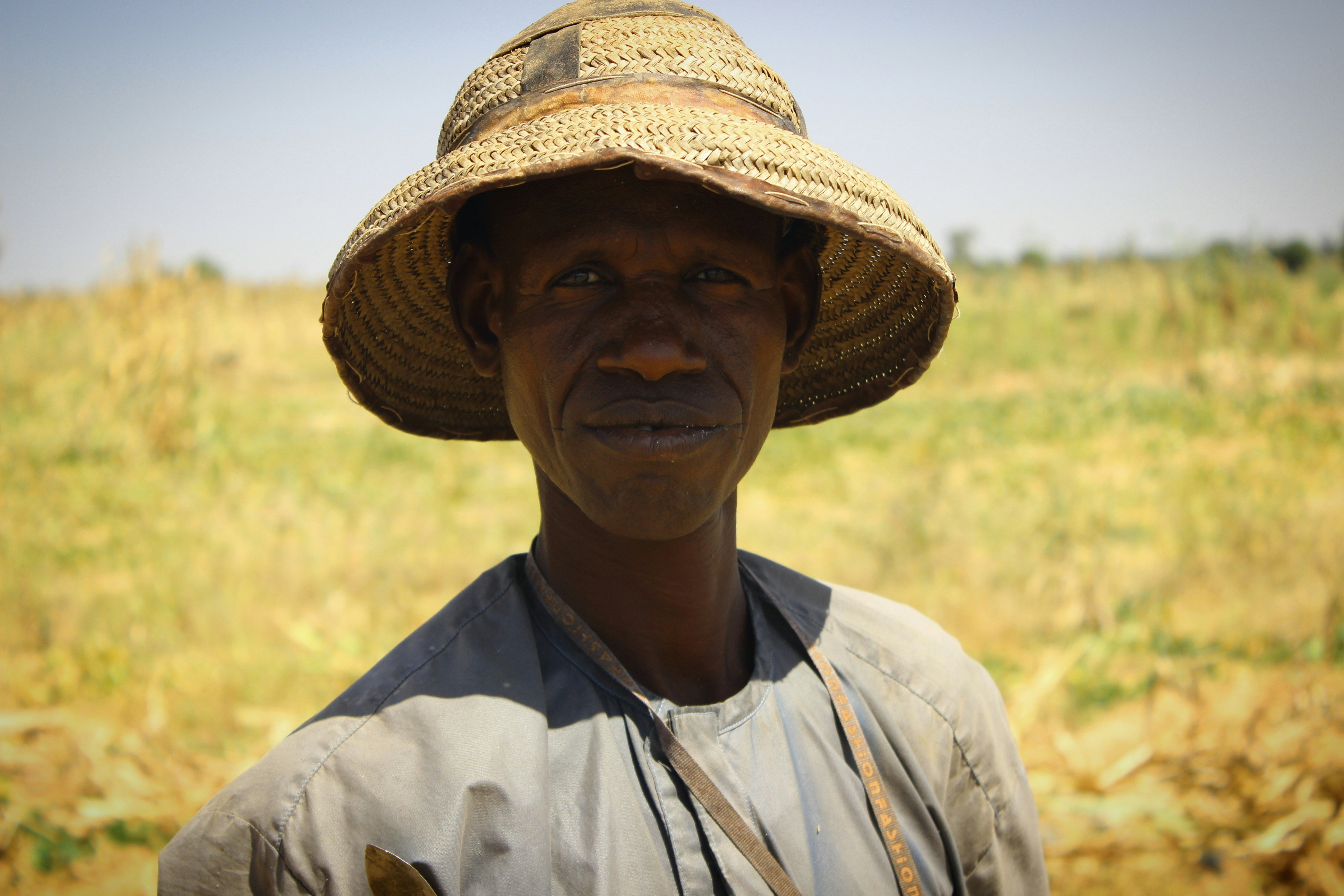 a man in a straw hat standing in a field